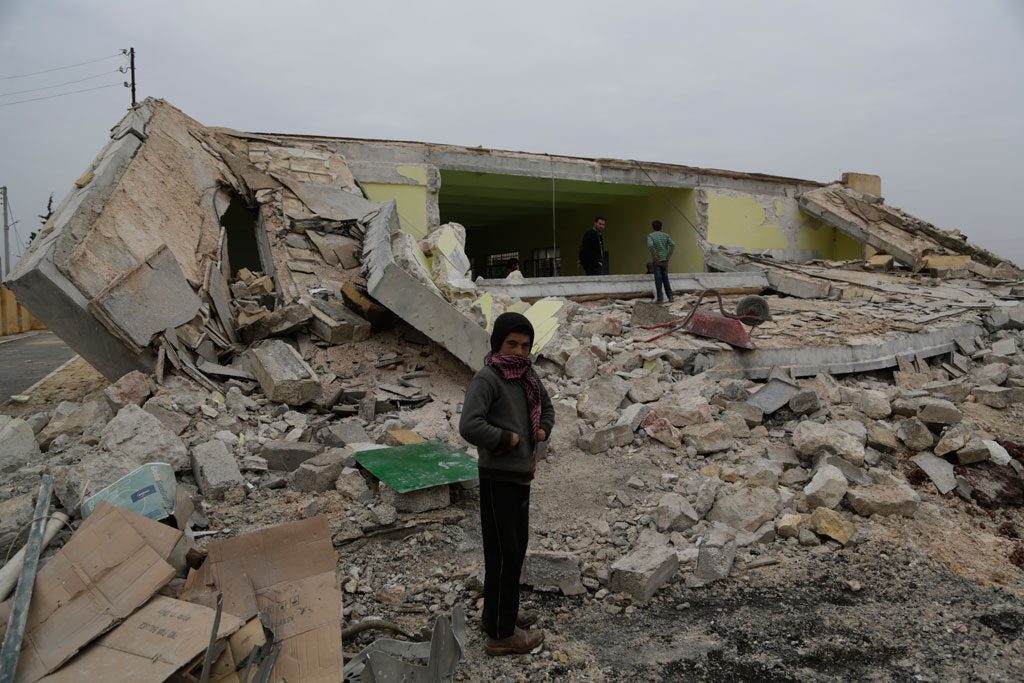 A child standing in front of his ground-flattened school after a bombardment in Ainjara village in rural Aleppo, Syria. Photo: UNICEF/Khalil Alshawi