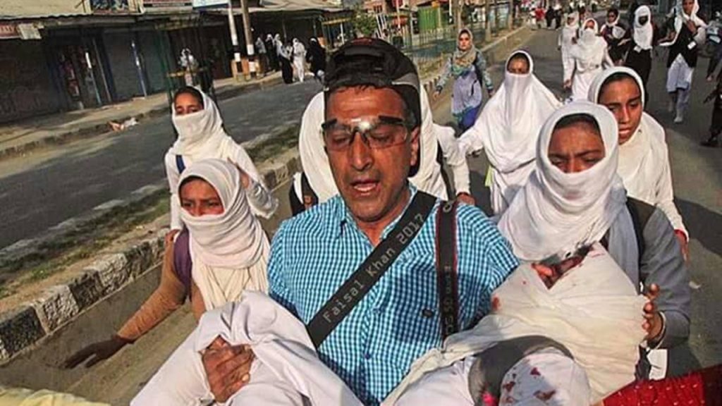 AP photographer Yasin Dar carrying an injured Kashmiri teen to safety. Photo courtesy Faisal Khan