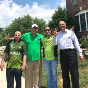 Cricket fans in green shirts with victory signs
