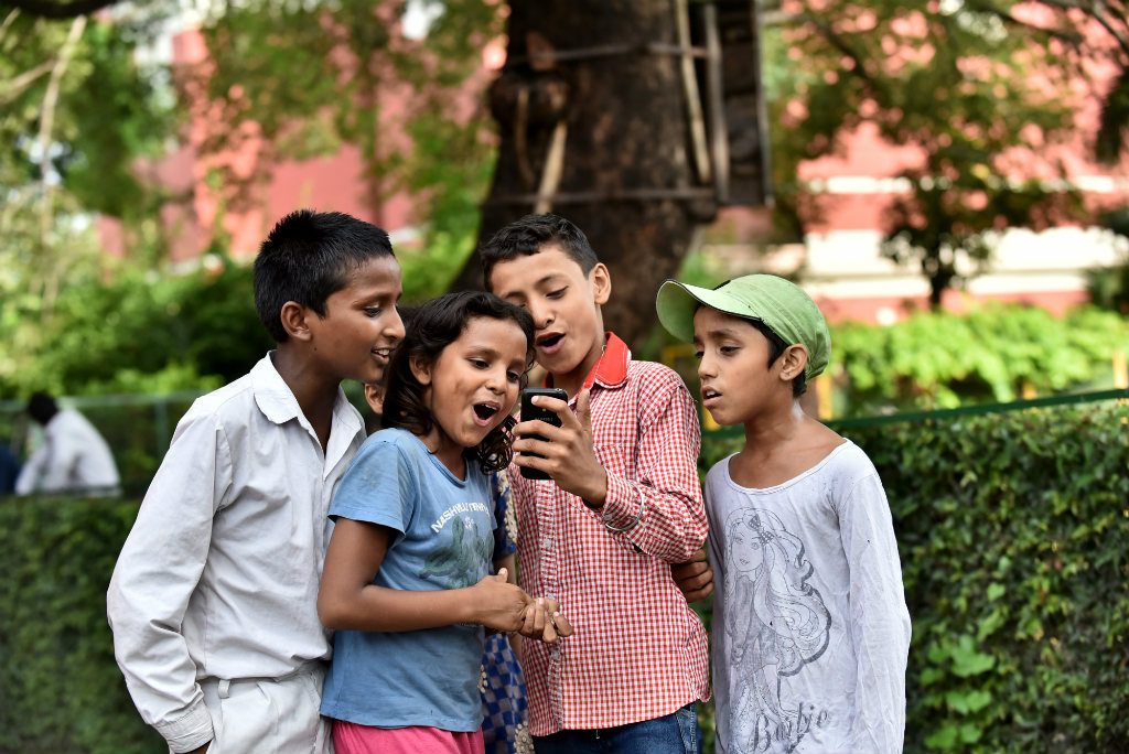 Children at St. Columba’s School, Delhi, India, use a mobile phone Photo: Ashutosh Sharma/UNICEF