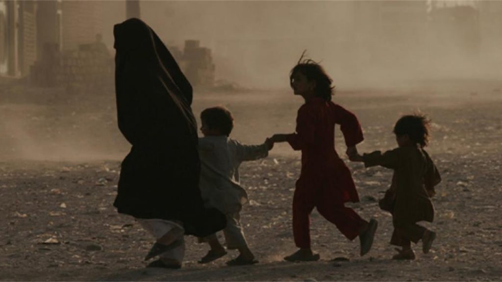 Photo: UNAMA / Fraidoon Poya A family struggles through a dusty environment in Afghanistan 