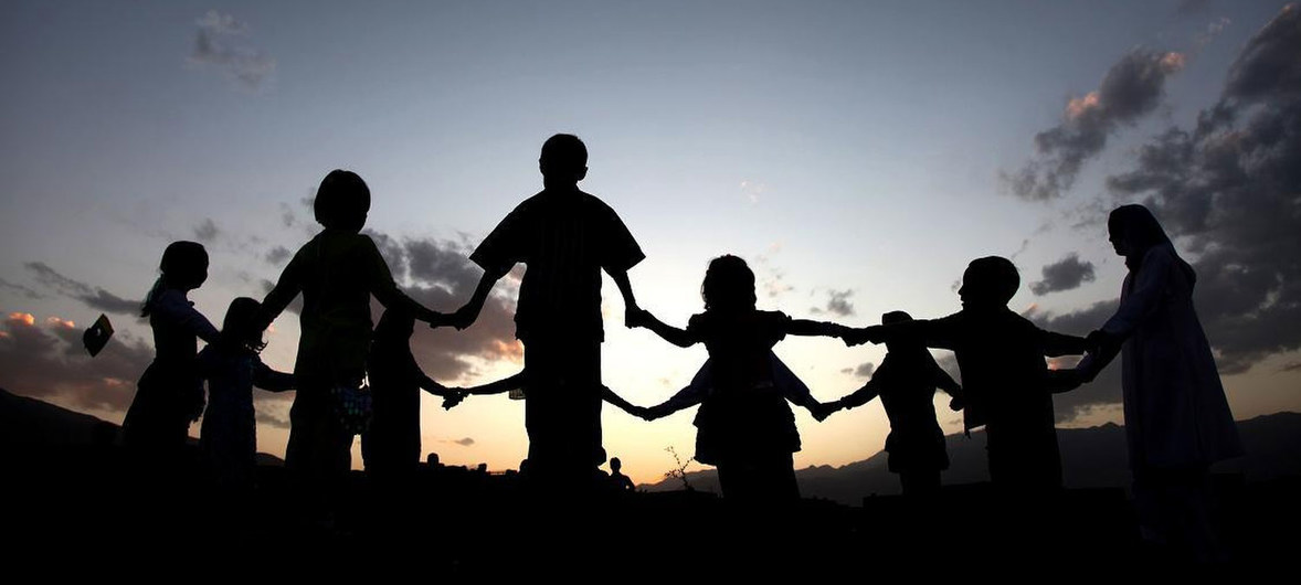 Afghan school children hold hands and take advantage of the last few moments of sunlight to finish their game UN photo by Najeeb Farzad